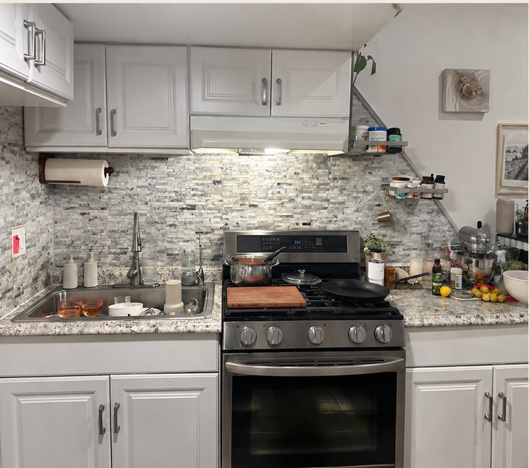 Kitchen before cleaning with dishes in the sink and pans on the stove